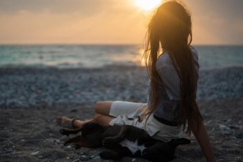 Frau-mit-Welpe-am-Strand-Sonnenuntergang-pexels-pnw-production.jpg